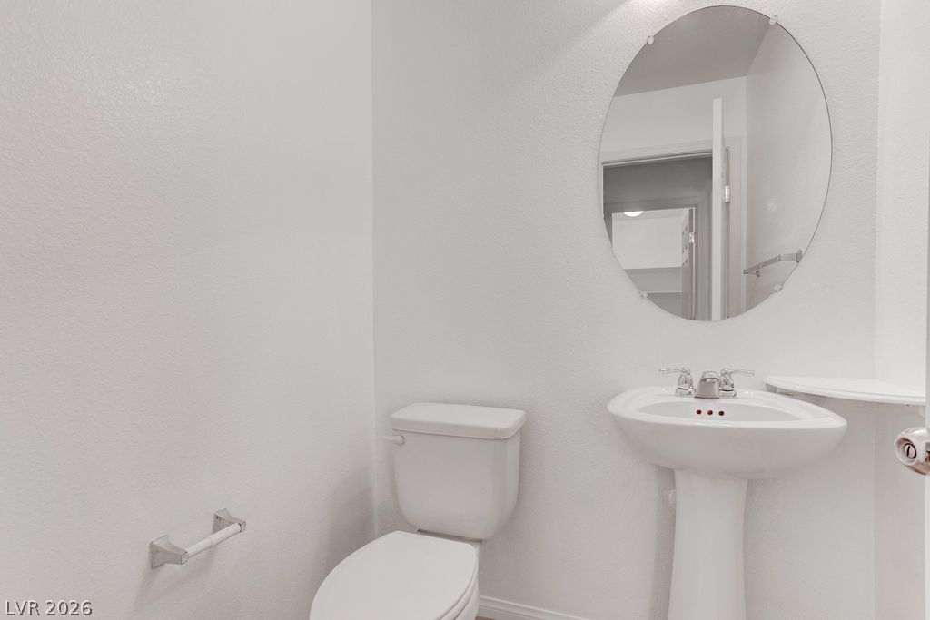 4650 Ranch House Road, Unit 47 North Las Vegas, NV 89031 - Photo 16 of 43 A well-appointed powder room features a classic pedestal sink and an elegant circular mirror.