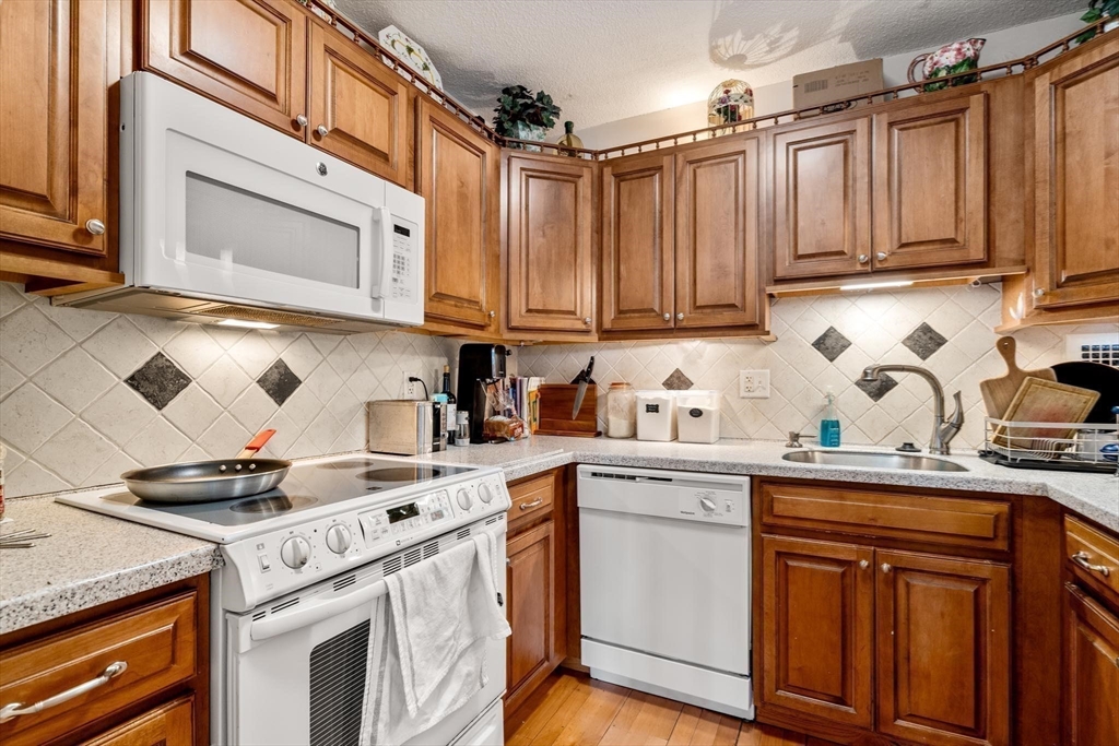 111 Perkins Street, Unit 83 Boston, MA 02130 - Photo 9 of 20 a kitchen with stainless steel appliances granite countertop a sink a stove and cabinets