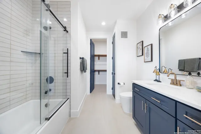 a bathroom with a tub sink double vanity and a shower
