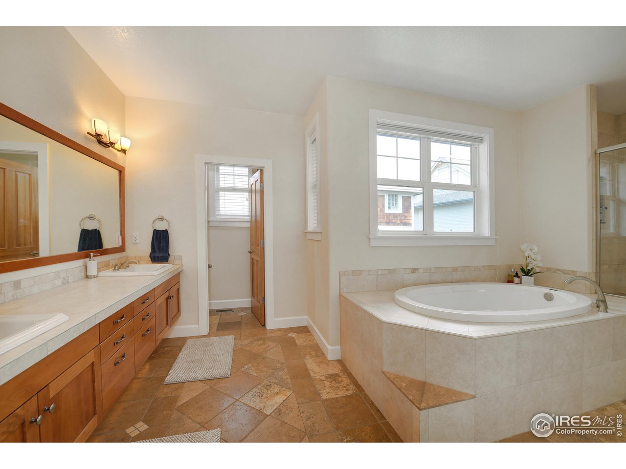 755 Terrace Circle South Boulder, CO 80304 - Photo 25 of 38 a bathroom with a granite countertop sink mirror bathtub and double