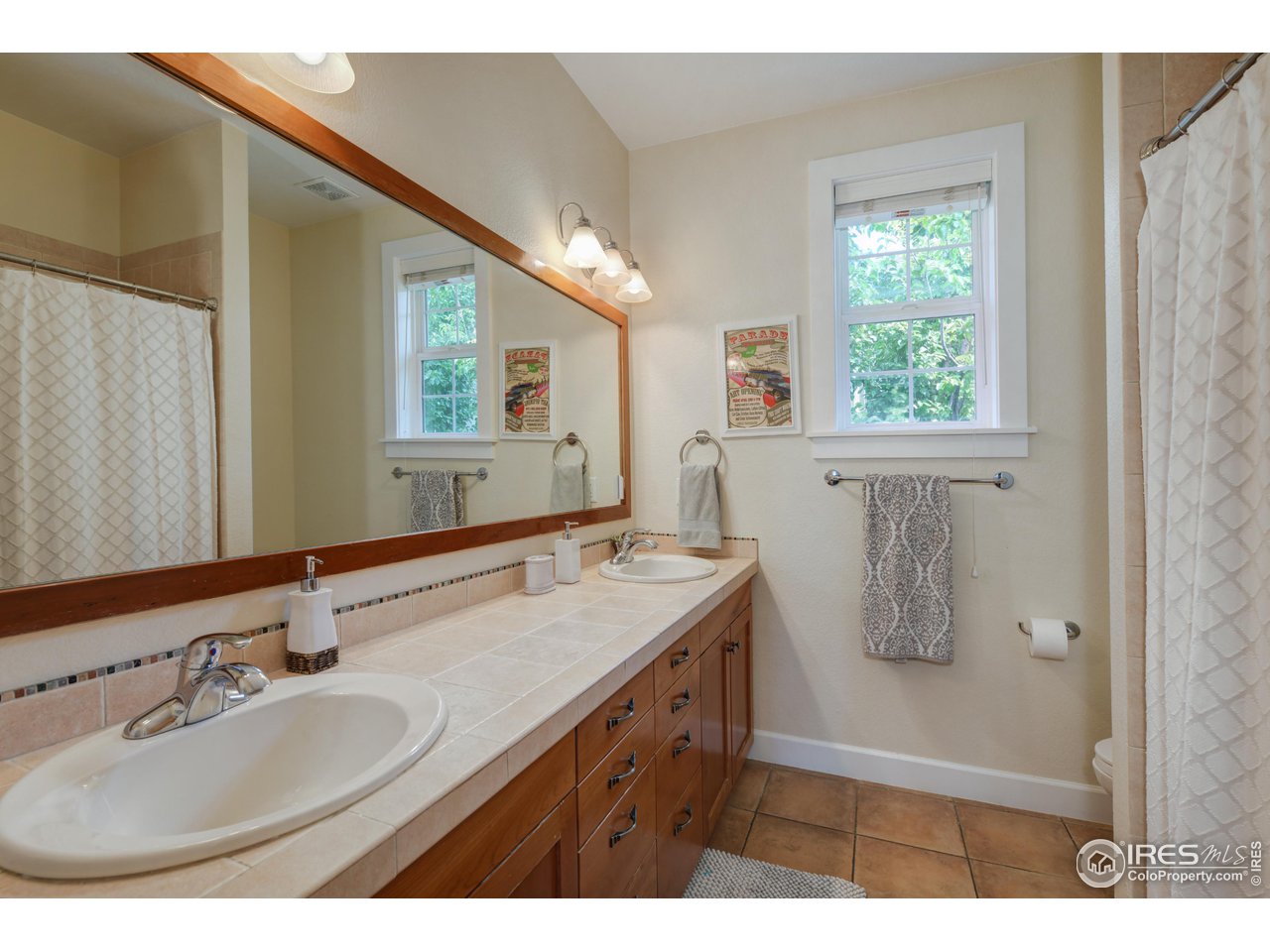 755 Terrace Circle South Boulder, CO 80304 - Photo 28 of 38 a bathroom with a granite countertop sink a mirror and a