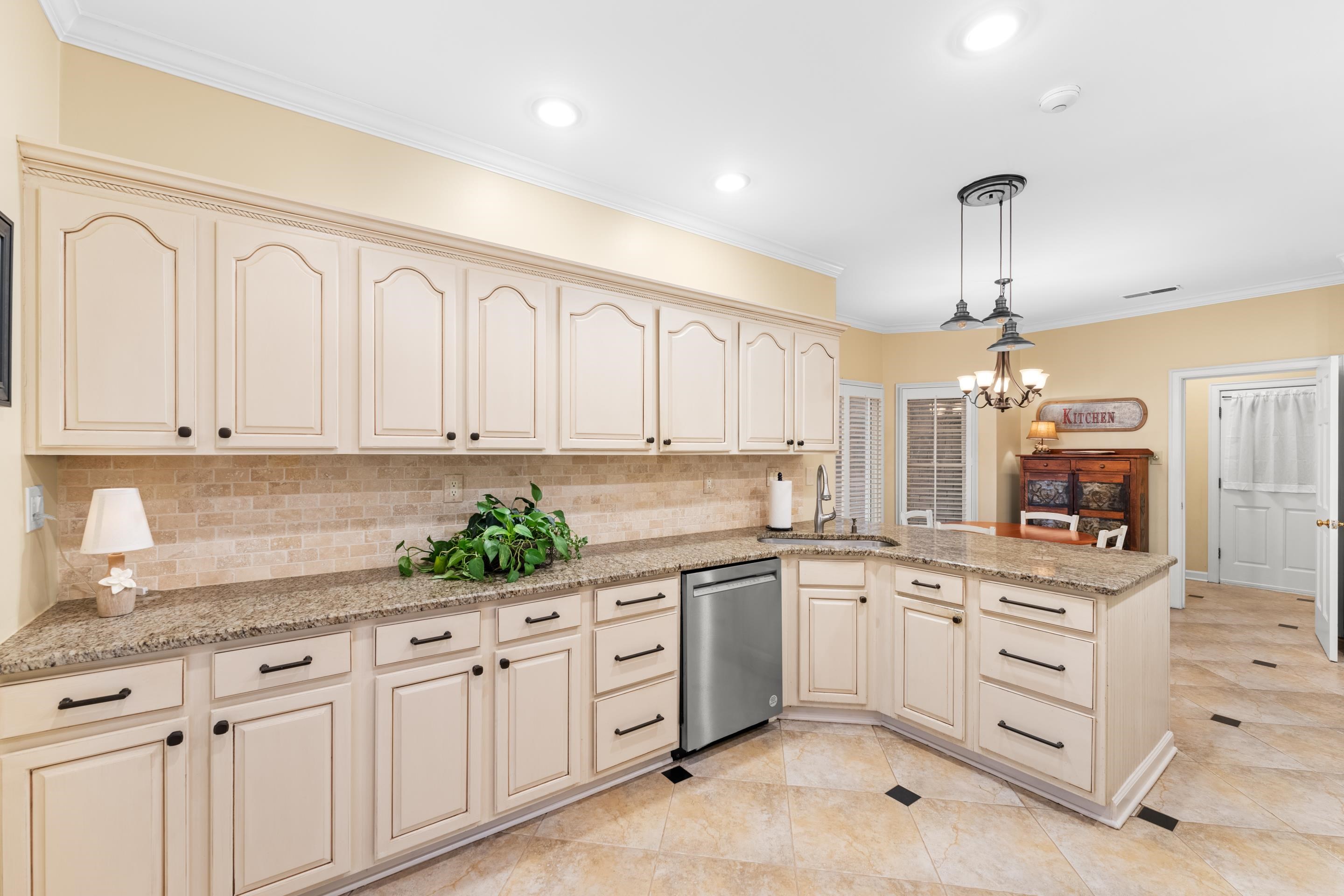 3430 Shea Road Collierville, TN 38017 - Photo 13 of 40 a kitchen with white cabinets and chandelier
