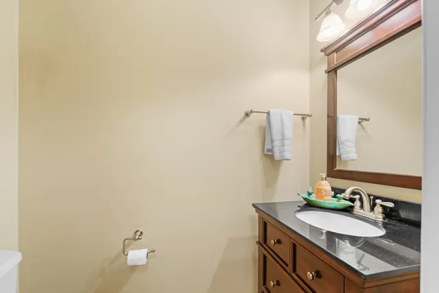 a bathroom with a granite countertop sink and a mirror