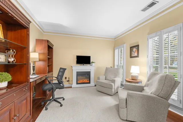 a living room with furniture a flat screen tv and a window