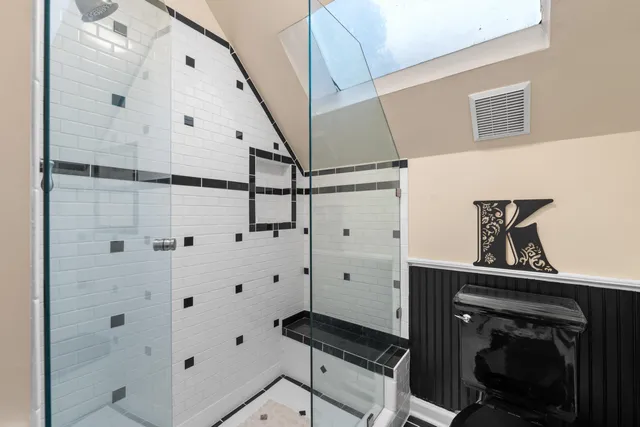 a spacious bedroom with a large bed and a chandelier