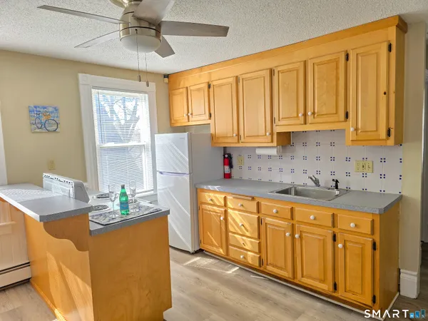 a kitchen with stainless steel appliances granite countertop a sink a stove cabinets counter space and a window