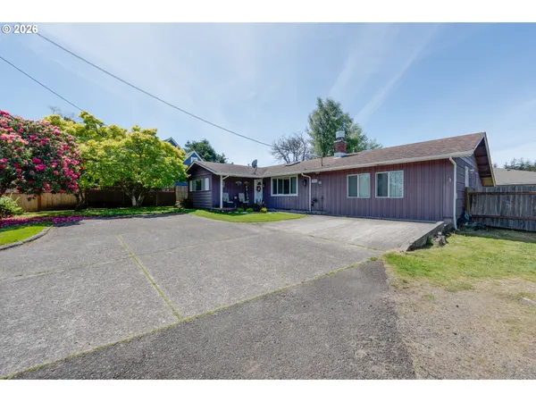 a view of a house with a yard and potted plants