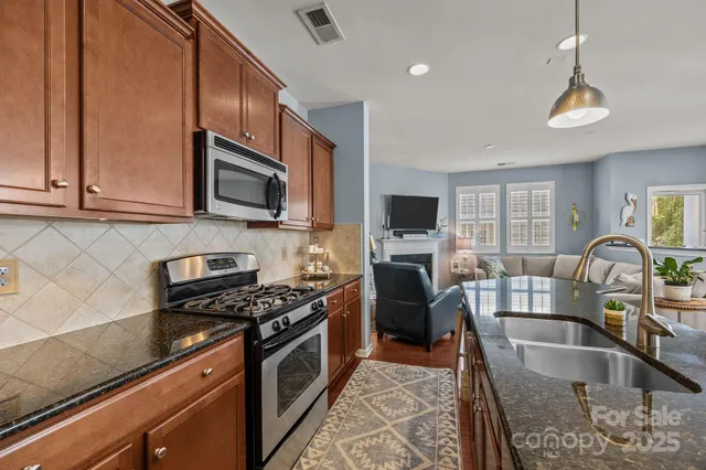 a kitchen with granite countertop a stove a sink and a microwave