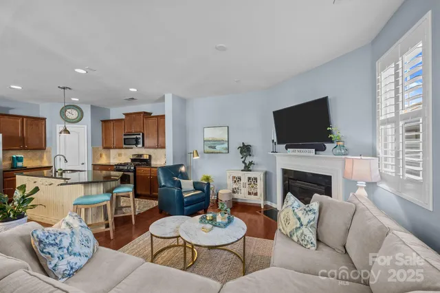 a living room with furniture a fireplace and a flat screen tv