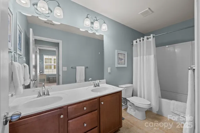 a bathroom with a double vanity sink mirror and toilet