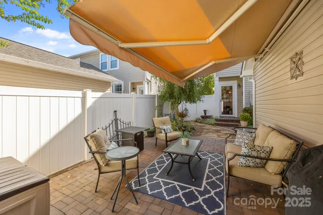 a view of a patio with table and chairs and floor to ceiling window with wooden floor