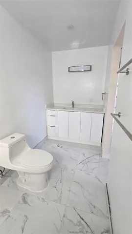 a bathroom with a toilet and a mirror