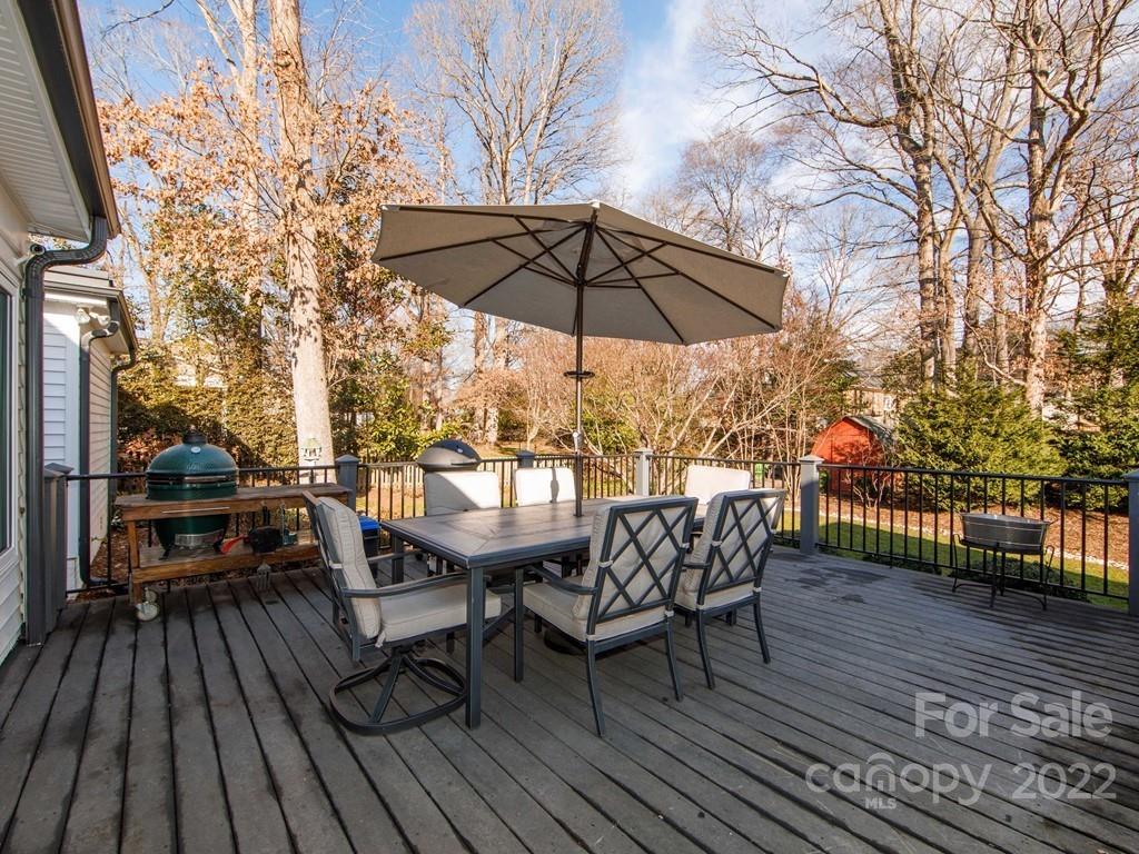 1000 Braeburn Road Charlotte, NC 28211 - Photo 47 of 48 a view of deck with table and chairs under an umbrella with wooden floor and fence