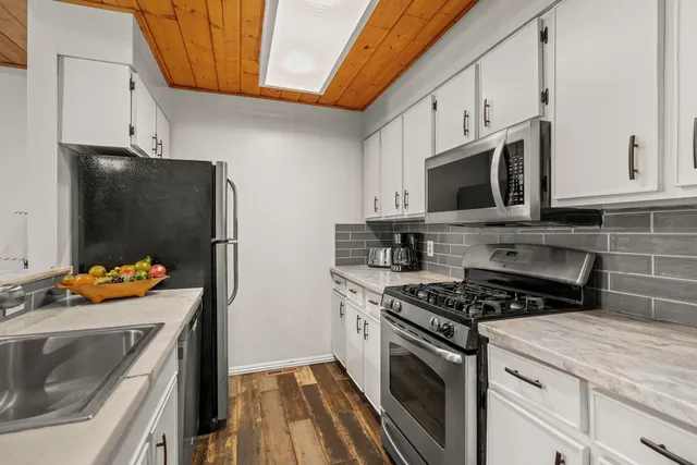 a kitchen with stainless steel appliances a stove microwave and refrigerator