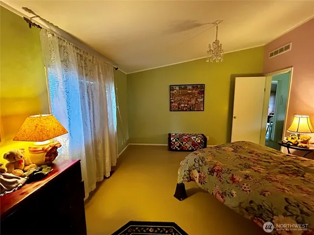 a bedroom with a bed and a chandelier