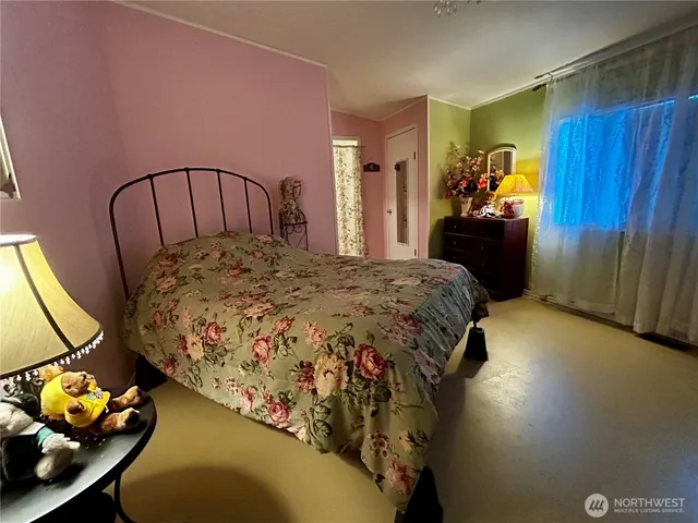 a bedroom with a bed a dresser and potted plants on the table