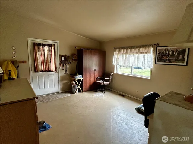 a view of a livingroom with workspace and a window