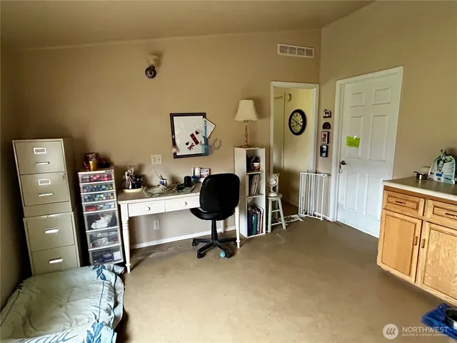 a view of a workspace with furniture and a window