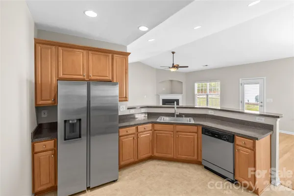 a kitchen with granite countertop white cabinets and black appliances