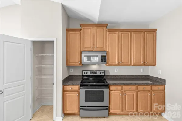 a kitchen with granite countertop a sink and stainless steel appliances