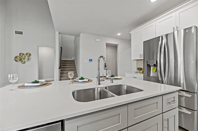 a kitchen with stainless steel appliances granite countertop a sink and a refrigerator