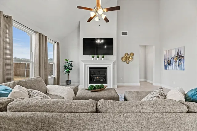 a living room with furniture a flat screen tv and a fireplace