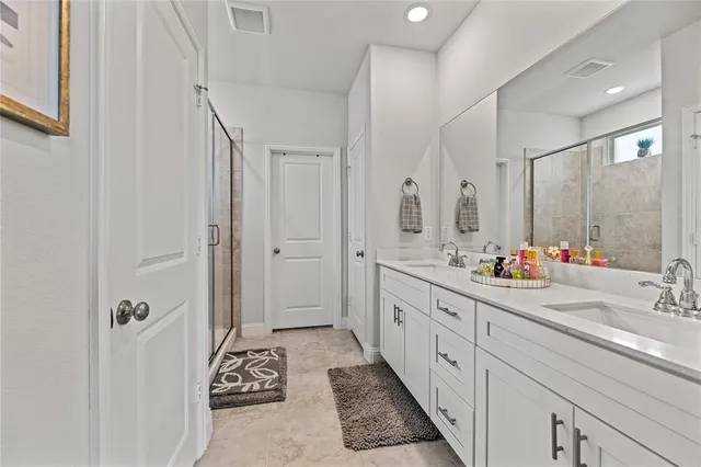 a spacious bathroom with double vanity and mirrors