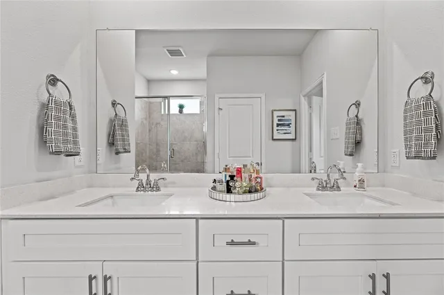 a bathroom with double vanity sinks and a mirror
