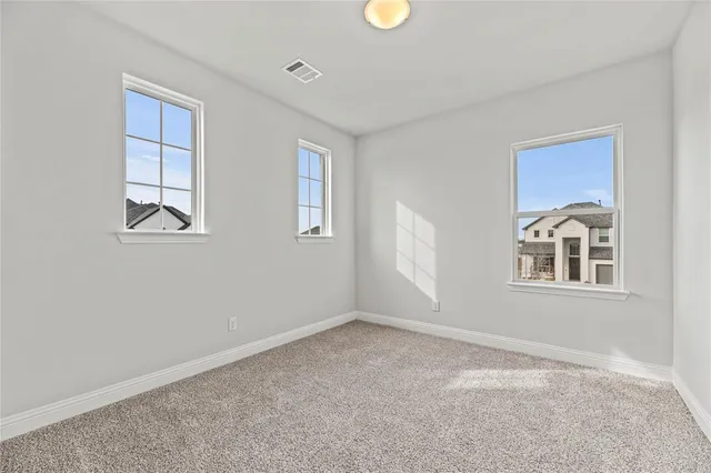 a view of an empty room with closet and window