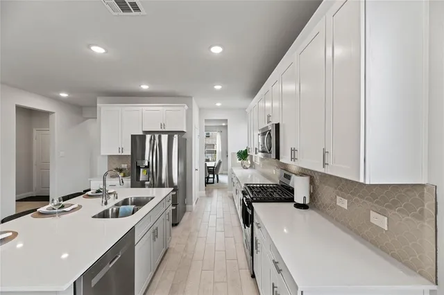 a kitchen with stainless steel appliances a sink stove and refrigerator
