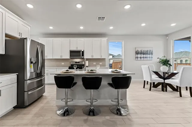a large kitchen with a table and chairs