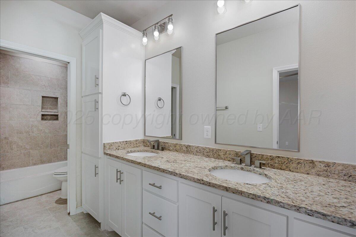 4302 Beacon Road Amarillo, TX 79118 - Photo 12 of 20 a bathroom with a granite countertop sink and a mirror