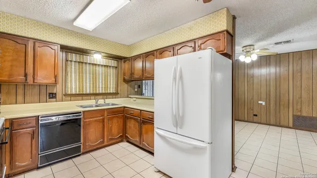 a kitchen with a refrigerator sink and cabinets