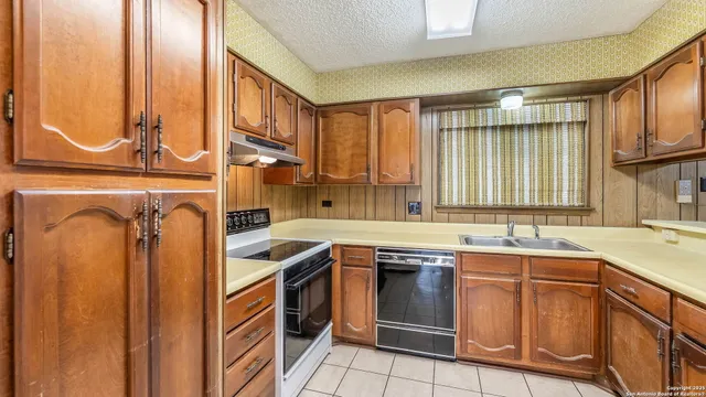 a kitchen with stainless steel appliances granite countertop a sink and a refrigerator