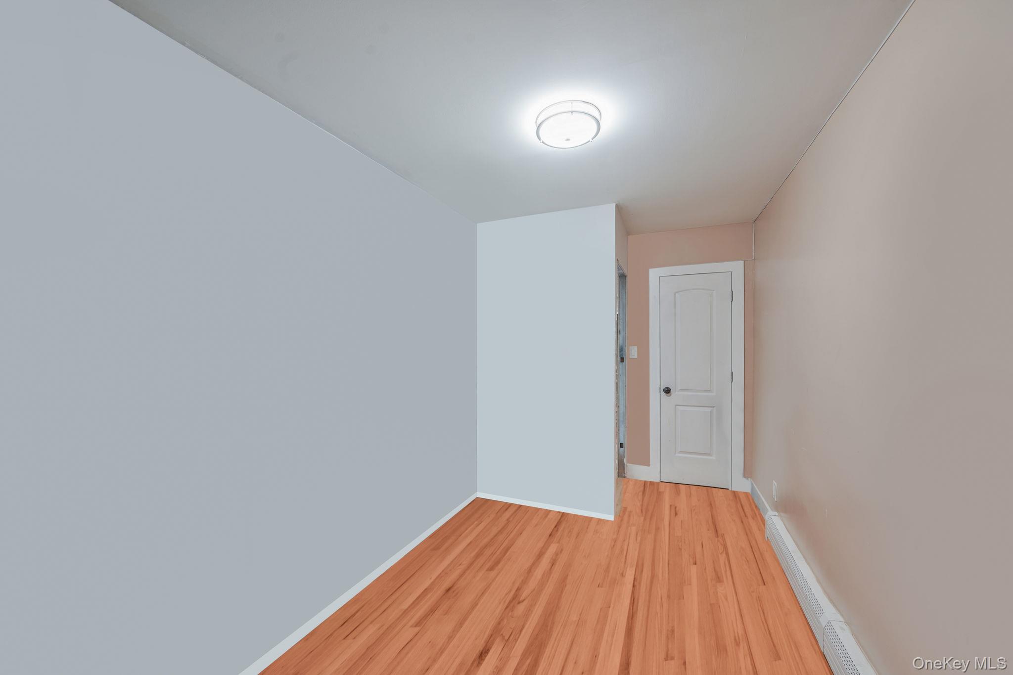 202-02 109th Avenue Queens, NY 11412 - Photo 19 of 26 Spare room featuring wood finished floors and baseboard heating