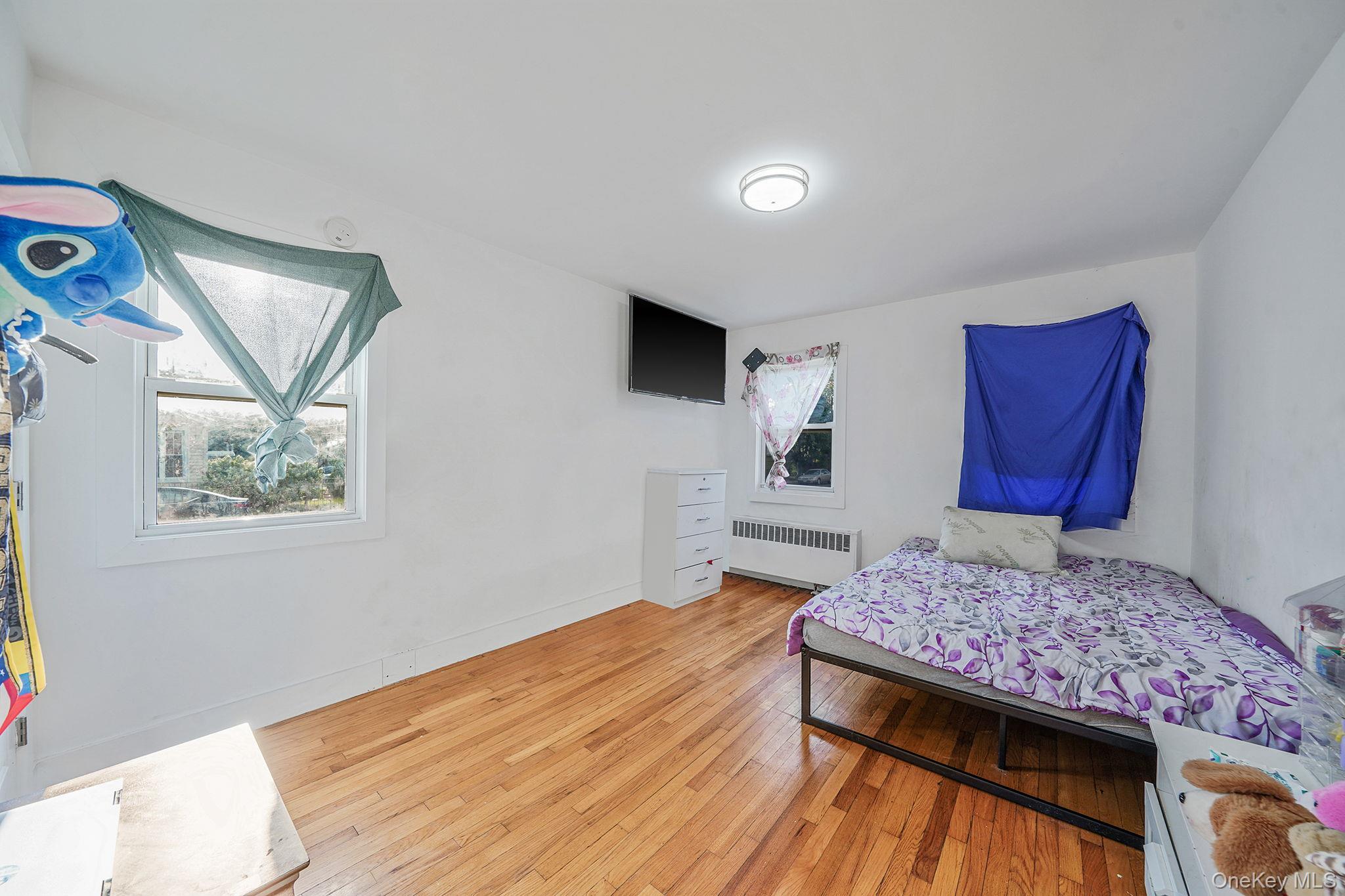 202-02 109th Avenue Queens, NY 11412 - Photo 20 of 26 Bedroom featuring light wood finished floors and radiator heating unit