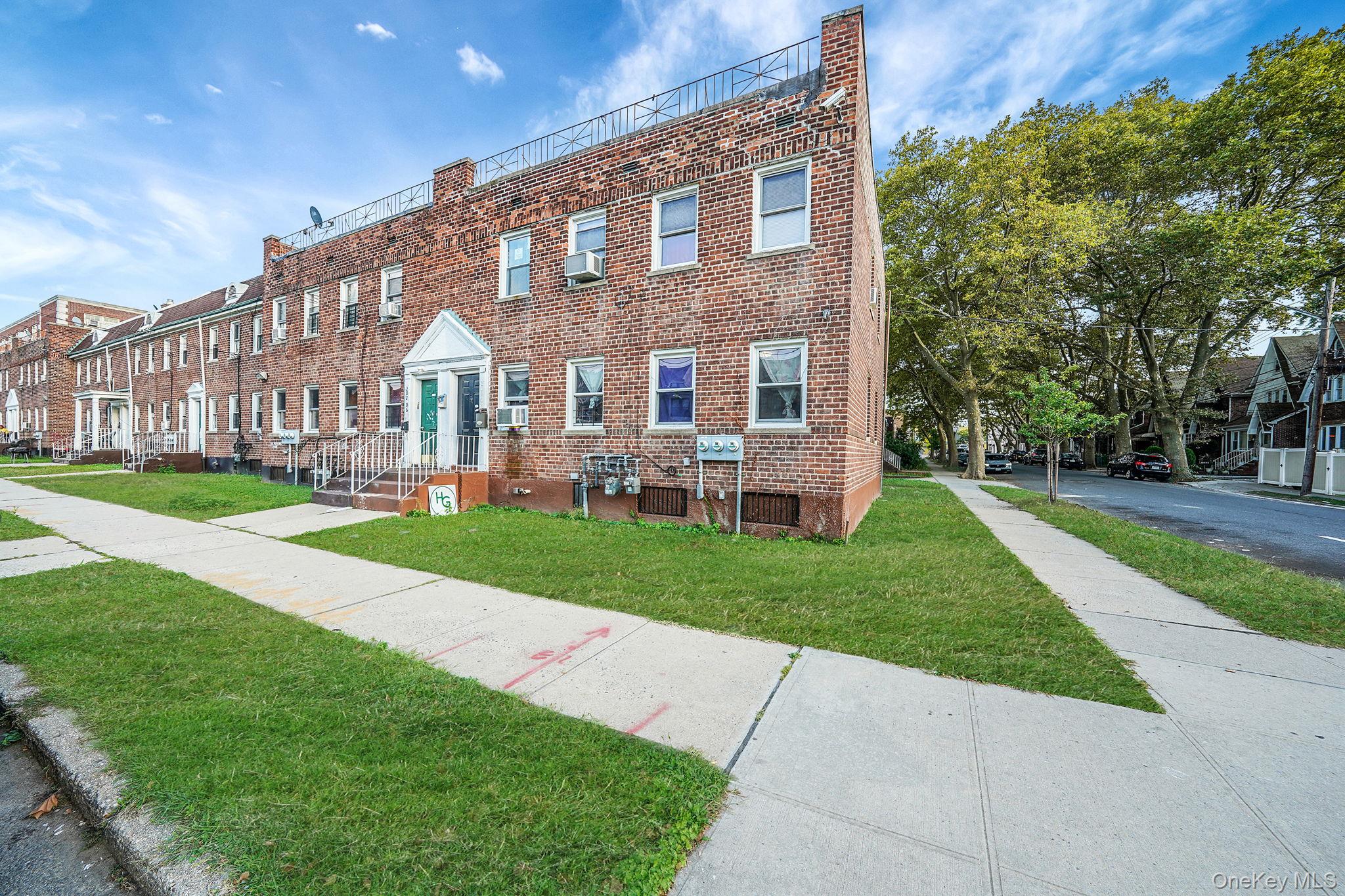 202-02 109th Avenue Queens, NY 11412 - Photo 3 of 26 View of front facade with a front lawn, a residential view, and brick siding