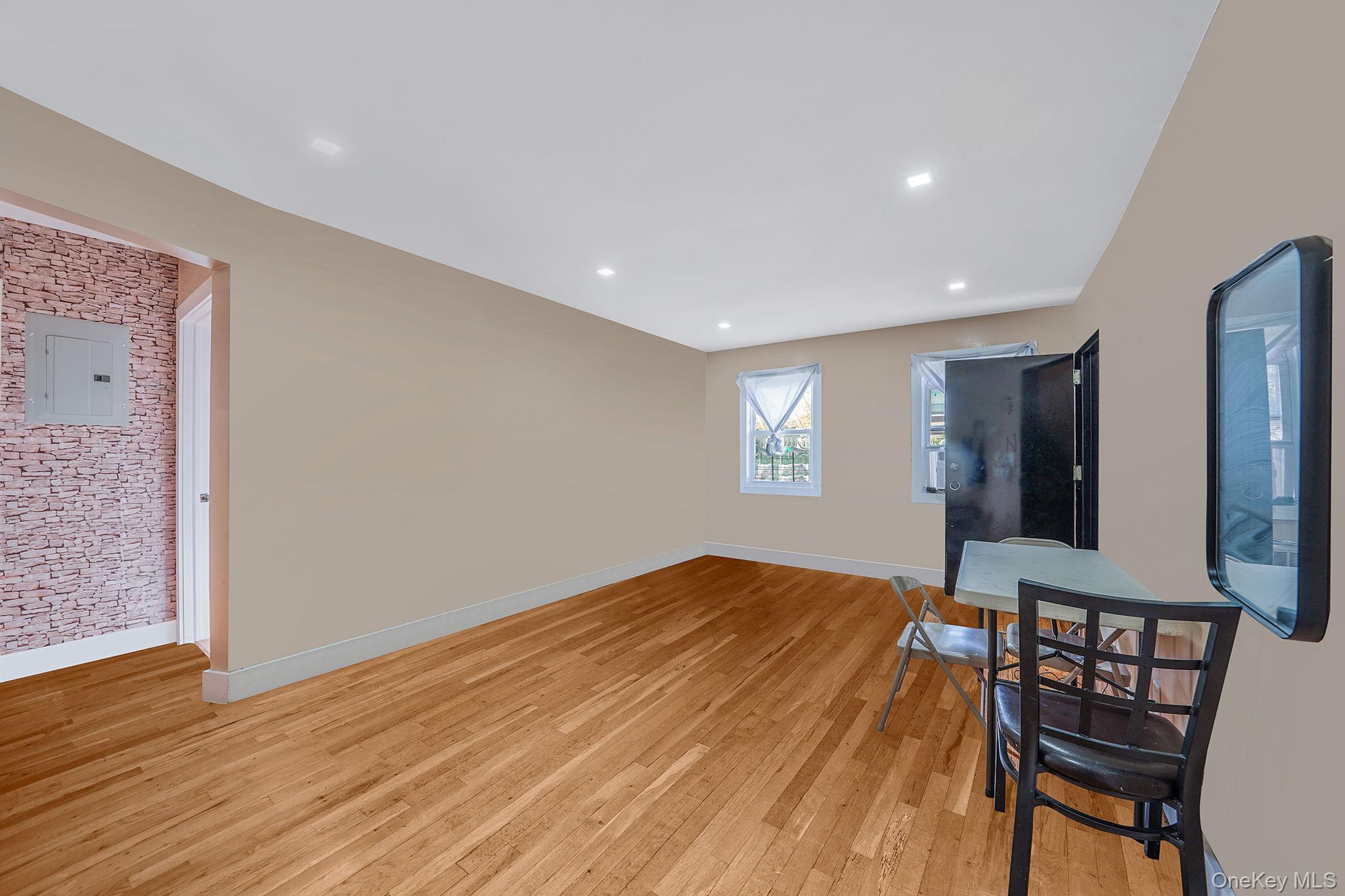 202-02 109th Avenue Queens, NY 11412 - Photo 10 of 26 Unfurnished living room featuring light wood-style floors, electric panel, and recessed lighting