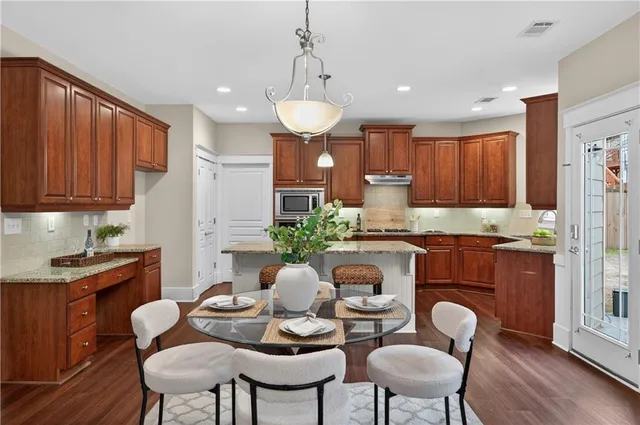 a view of a white house with potted plants and a small yard