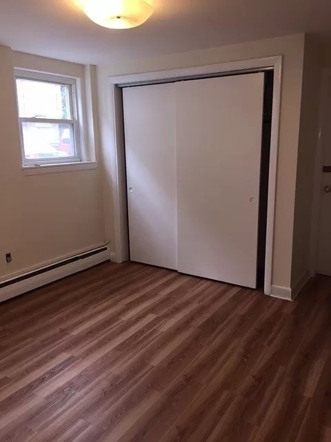 60 Parkman Street, Unit A1 Brookline, MA 02446 - Photo 3 of 6 an empty room with wooden floor and windows