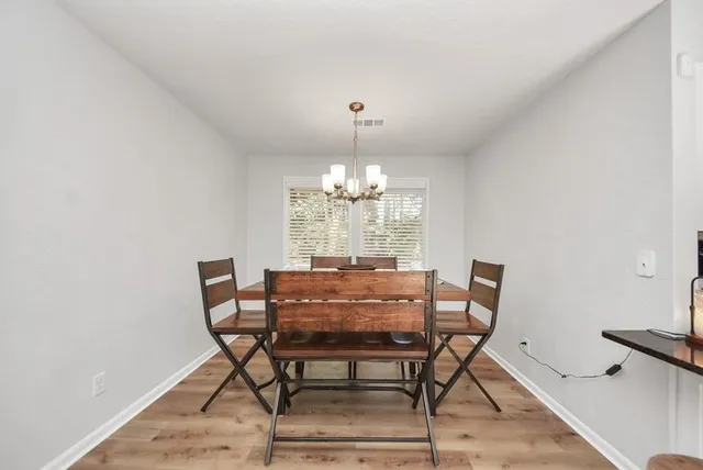 a view of a dining room with furniture and chandelier