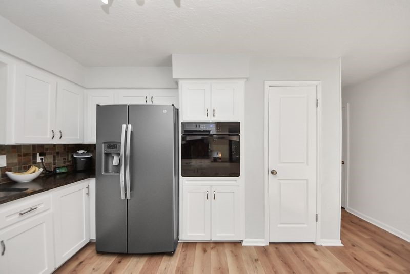 155 Springs Edge Drive Conroe, TX 77356 - Photo 19 of 49 a kitchen with stainless steel appliances a refrigerator and cabinets