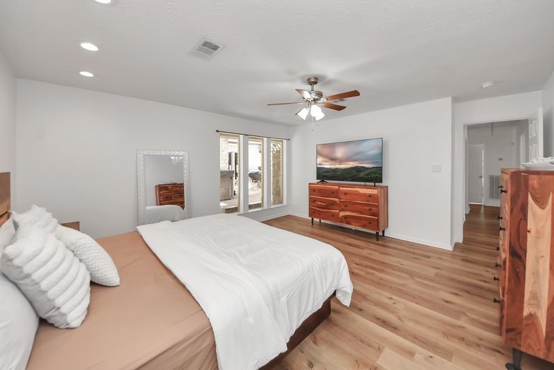 155 Springs Edge Drive Conroe, TX 77356 - Photo 23 of 49 a spacious bedroom with a bed and a chandelier