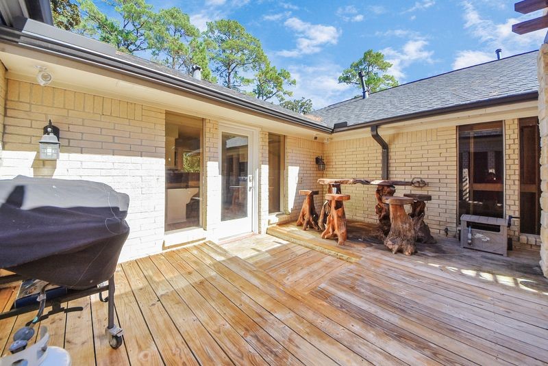 155 Springs Edge Drive Conroe, TX 77356 - Photo 40 of 49 a view of a patio with table and chairs with wooden floor and fence