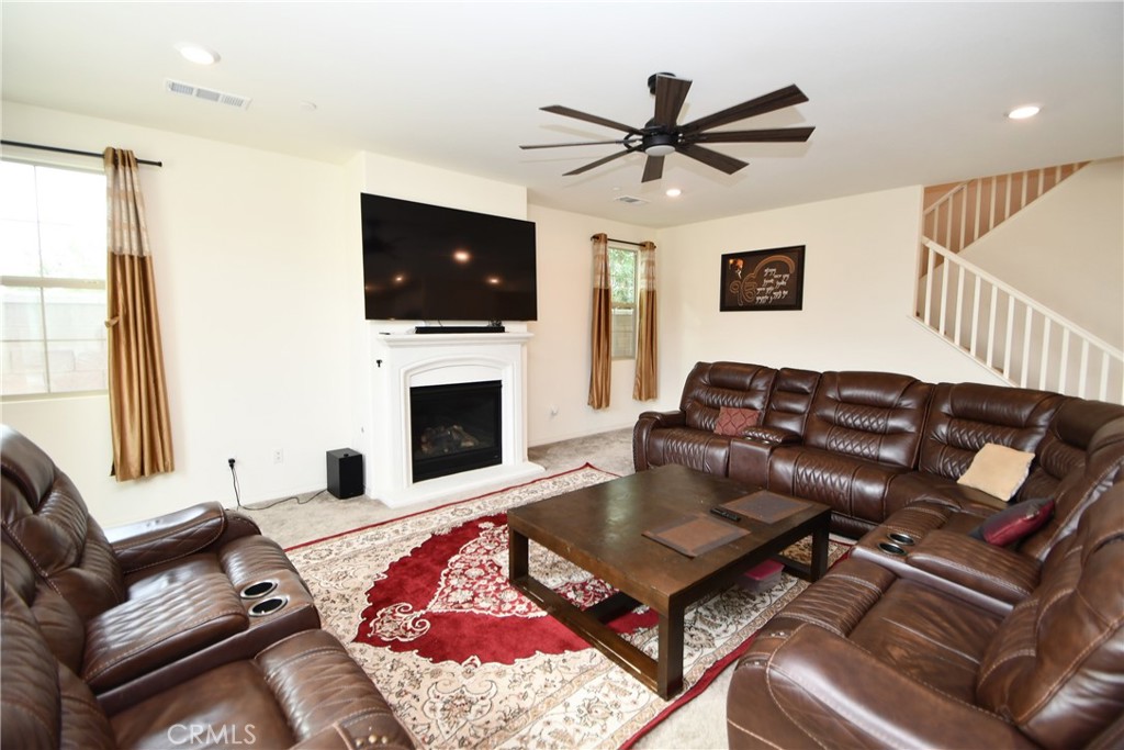 5367 Heitz Way Fontana, CA 92336 - Photo 13 of 50 a living room with furniture a flat screen tv and a fireplace