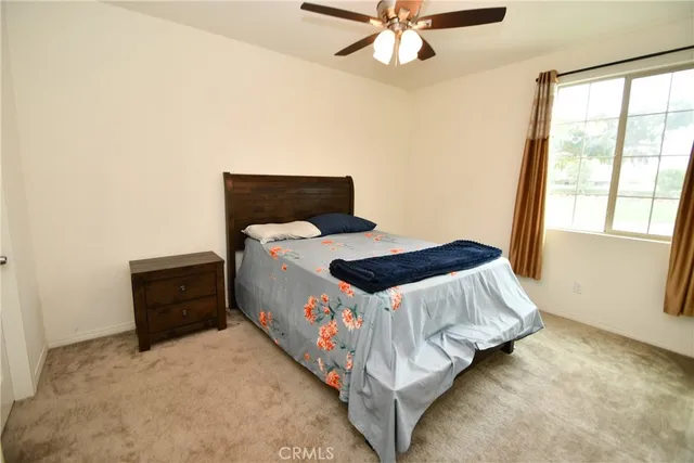 a bedroom with a bed and a ceiling fan