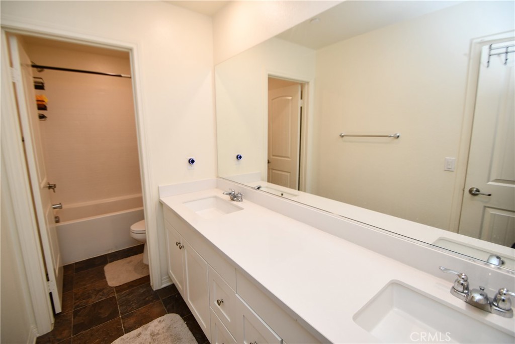 5367 Heitz Way Fontana, CA 92336 - Photo 25 of 50 a bathroom with a double vanity sink a toilet and shower