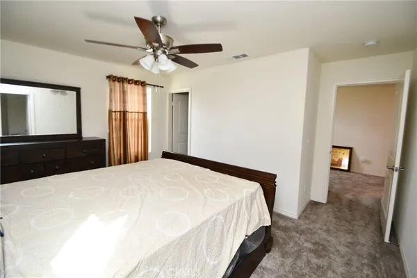 a bedroom with a bed and a ceiling fan
