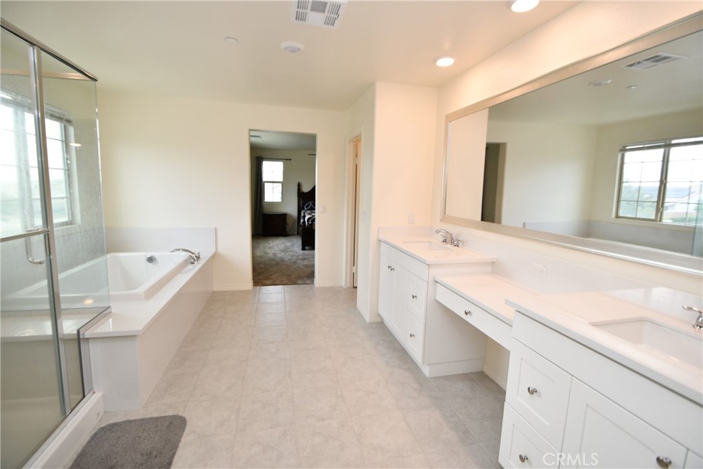 5367 Heitz Way Fontana, CA 92336 - Photo 43 of 50 a spacious bathroom with a granite countertop tub sink and mirror