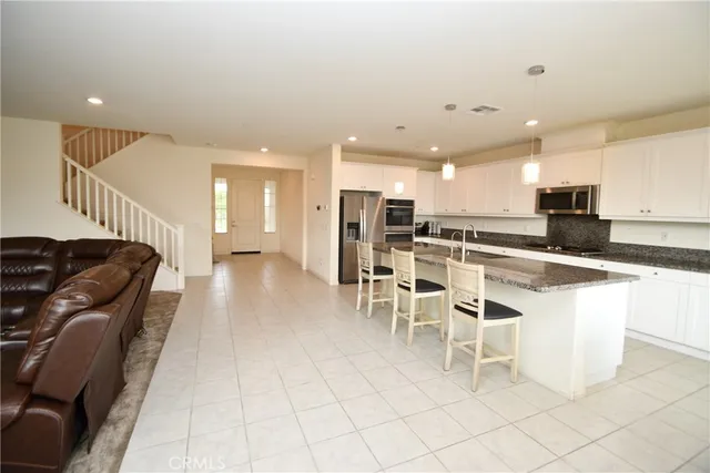 a large white kitchen with lots of counter space and furniture